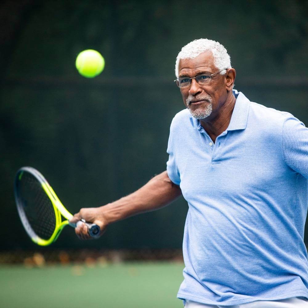 Senior tennis player practicing his form